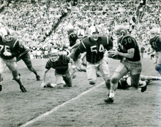 1959 Jerry Mays (75) and Max Christian Close In On Navy Runner